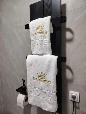 a stack of towels with a crown on them in a bathroom at Lux Veritas- besplatan parking-100 metara od Vinarije Grabak in Vrnjačka Banja