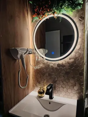a bathroom sink with a blow dryer on a mirror at Lux Veritas- besplatan parking-100 metara od Vinarije Grabak in Vrnjačka Banja