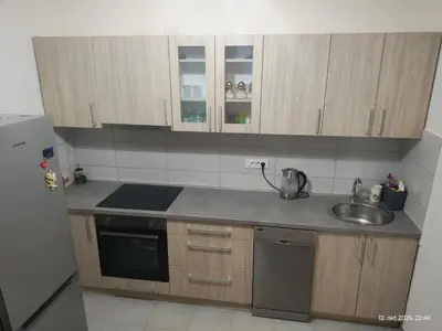 a small kitchen with wooden cabinets and a sink at Apartman Novak in Trnava