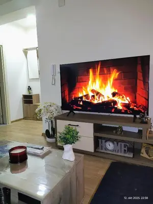 a fireplace in a living room with a fire pit at Apartman Novak in Trnava
