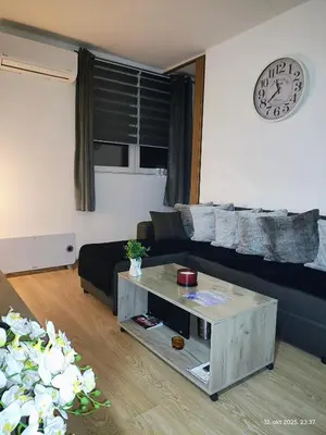 a living room with a black couch and a coffee table at Apartman Novak in Trnava