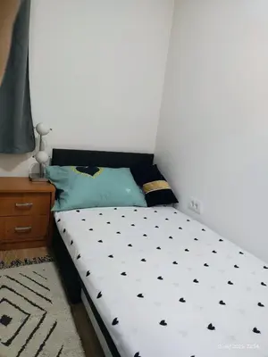 a small bed with a black and white comforter at Apartman Novak in Trnava