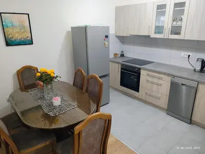 a kitchen with a table with a vase of flowers on it at Apartman Novak in Trnava