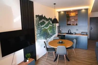 a kitchen and dining room with a table and chairs at Hillview B117 in Kopaonik