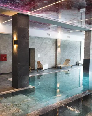 a pool in a building with two chairs in it at Hillview B117 in Kopaonik