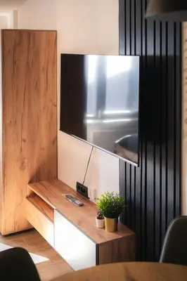 a tv on a wall next to a table at Hillview B117 in Kopaonik