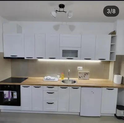 a kitchen with white cabinets and a sink at Apartmani Vrnjacka Banja 8 in Vrnjci
