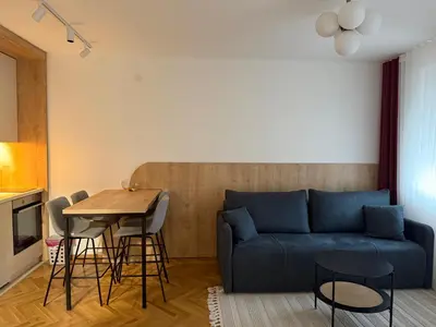 a living room with a blue couch and a table at Apartman Vrnjacka Banja in Vrnjci