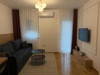 a living room with a couch and a tv at Apartman Vrnjacka Banja in Vrnjci