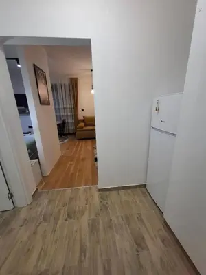 a living room with white walls and a wooden floor at DragonVB in Vrnjačka Banja