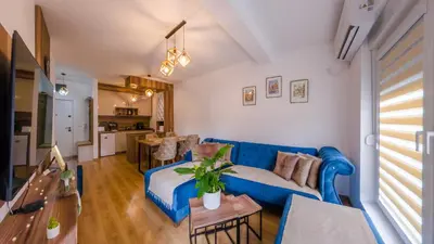 a living room with a blue couch and a table at Portofino in Vrnjačka Banja