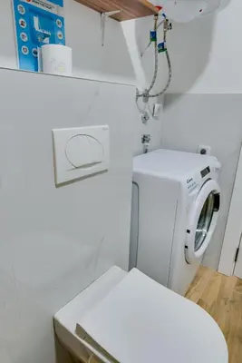 a bathroom with a washing machine and a toilet at Portofino in Vrnjačka Banja