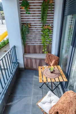 a patio with a table and a chair on a balcony at Portofino in Vrnjačka Banja