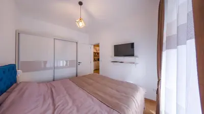 a bedroom with a bed and a flat screen tv at Portofino in Vrnjačka Banja