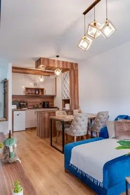 a bedroom and living room with a bed and a table at Portofino in Vrnjačka Banja