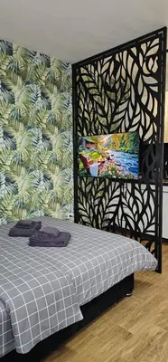a bedroom with a bed and a wall with a mural at Luna Apartmani in Soko Banja