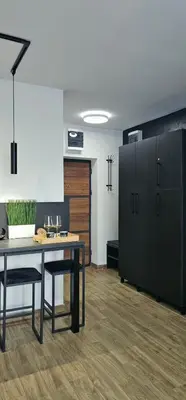 a dining room with a table and black cabinets at Luna Apartmani in Soko Banja