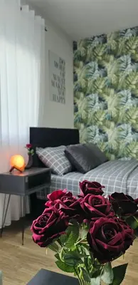 a room with two beds and a bouquet of red roses at Luna Apartmani in Soko Banja