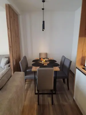 a dining room with a table and chairs and a couch at Whisper apartments Kopaonik in Kopaonik
