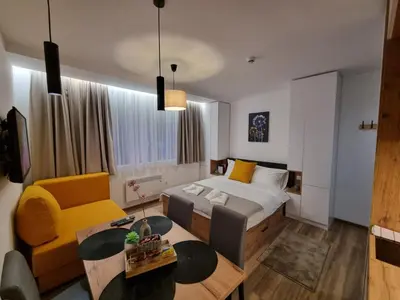 a bedroom with a bed and a couch and a table at Whisper apartments Kopaonik in Kopaonik