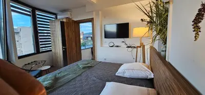 a bedroom with a bed and a large window at Elegant 406 Family Apartment in Vrnjačka Banja