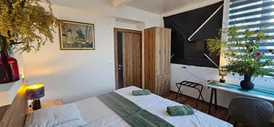 a bedroom with a bed and a desk and a window at Elegant 406 Family Apartment in Vrnjačka Banja