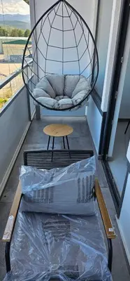 a swing on a balcony with a table and a box at Elegant 406 Family Apartment in Vrnjačka Banja