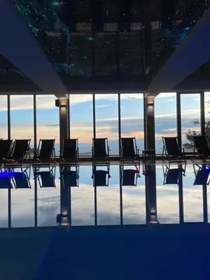 a swimming pool with chairs in a building at Pahuljica - N25 Milmari in Raška