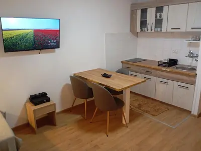 a small kitchen with a wooden table and chairs at Bela reka Gondola Studio in Brzeće