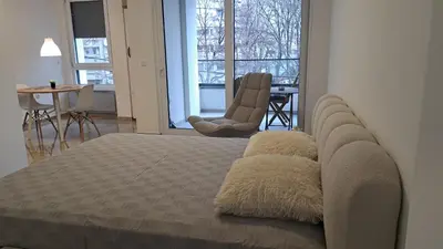 a bedroom with a bed and a table and chairs at Cloud in Niš