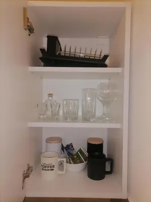 a shelf with various glasses and a tray on it at Cloud in Niš