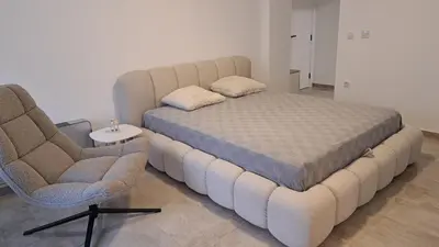 a bed and two chairs in a room at Cloud in Niš