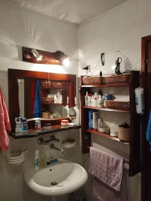 a bathroom with a sink and a mirror and shelves at Mountain home Borut in Kopaonik