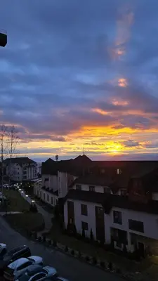 a sunset with cars parked in a parking lot at Apartman Harmonija in Kopaonik