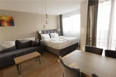 a room with a bed and a couch and a table at Apartman Harmonija in Kopaonik