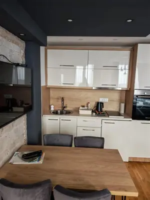 a kitchen with a wooden table and some chairs at Apartman Harmonija in Kopaonik