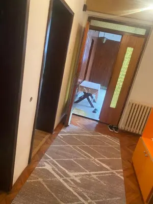 a hallway with an open door with a rug on the floor at Apartman Mina in Kuršumlija