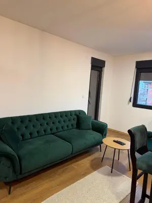 a living room with a green couch and a table at Emerald Residence in Vrnjačka Banja