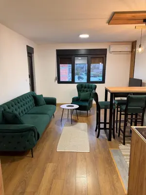 a living room with a couch and chairs and a table at Emerald Residence in Vrnjačka Banja