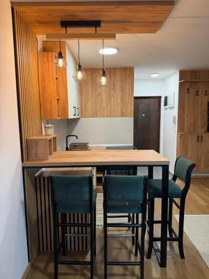 a kitchen with a wooden table and chairs at Emerald Residence in Vrnjačka Banja