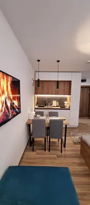 a living room with a table and a fireplace at SKYLINE apartments Kopaonik in Kopaonik