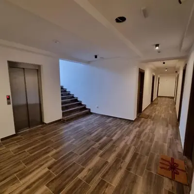 an empty room with stairs and white walls and wooden floors at SKYLINE apartments Kopaonik in Kopaonik
