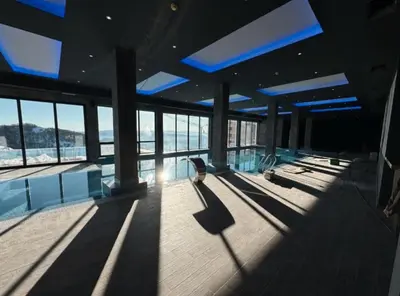 a large building with a swimming pool and windows at SKYLINE apartments Kopaonik in Kopaonik