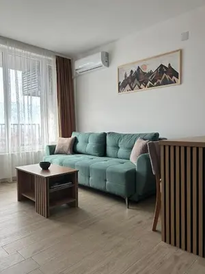 a living room with a blue couch and a table at Apartmani Mir in Soko Banja