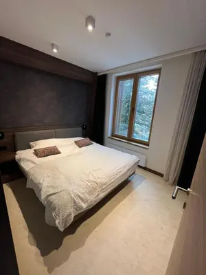 a bedroom with a bed and a large window at Centar slope apartman in Kopaonik