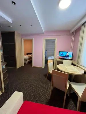 a room with a desk and a table and chairs at Centar slope apartman in Kopaonik