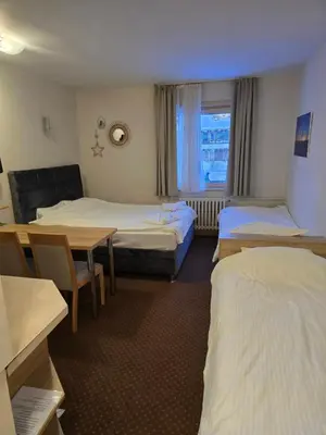 a hotel room with two beds and a table at Centar slope apartman in Kopaonik