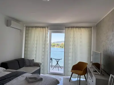 a bedroom with a window with a view of the water at Apartman studio BMB 1 in Bukorovac