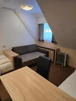 a living room with a couch and a chair at Cetar slope 2 apartman in Kopaonik