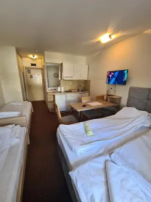 a hotel room with two beds and a kitchen at Centar slope 3 apartman in Kopaonik